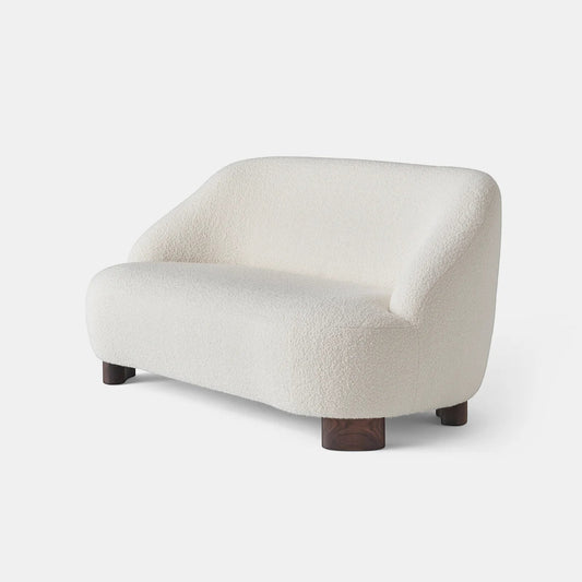 Ambrosia Concepts cream boucle 2-seater sofa with curved silhouette and dark wood legs, perfect for modern living rooms.