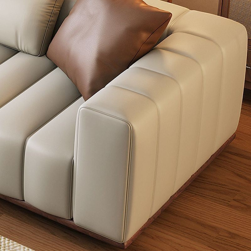 Ambrosia Concepts Pado 3-seater sofa in beige PU leather with fluted detailing and brown accent cushion.