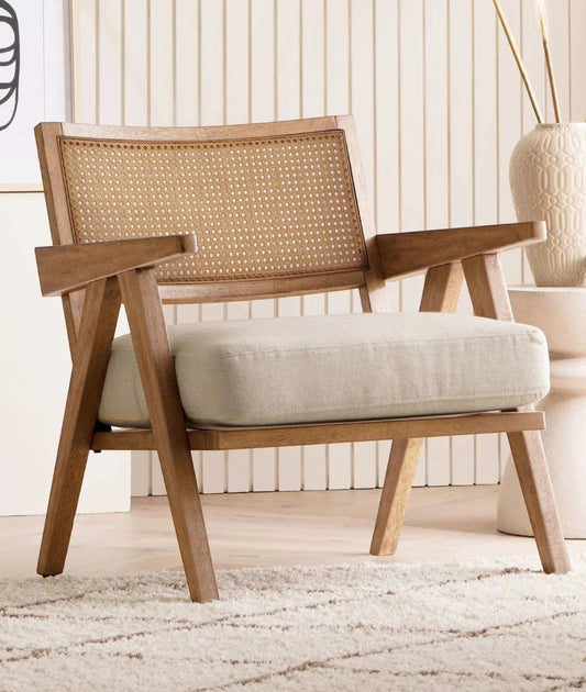 Ambrosia Concepts natural wood lounge chair with woven cane back and light beige cushion. Mid-century modern style.