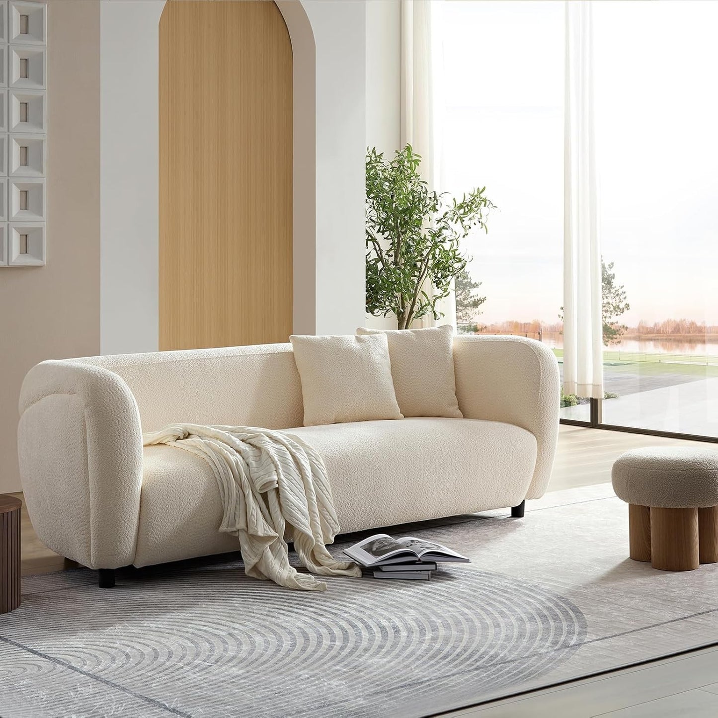Ambrosia Concepts cream boucle 3-seater sofa with curved silhouette and plush cushioning, featuring a knitted throw.