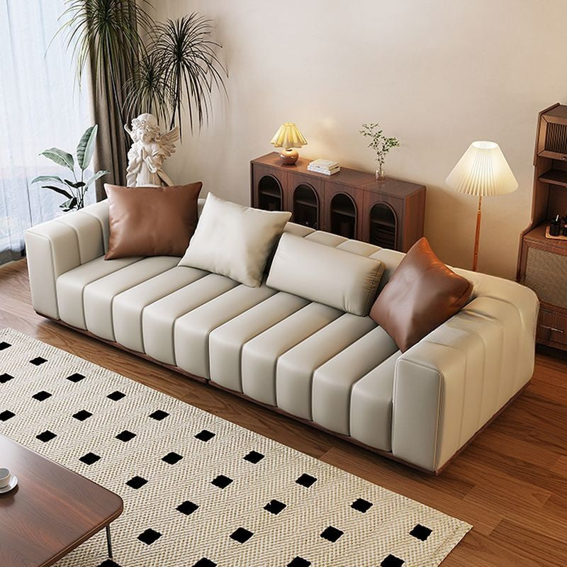 Ambrosia Concepts Pado 3-seater sofa in beige PU leather with fluted design and brown accent pillows.