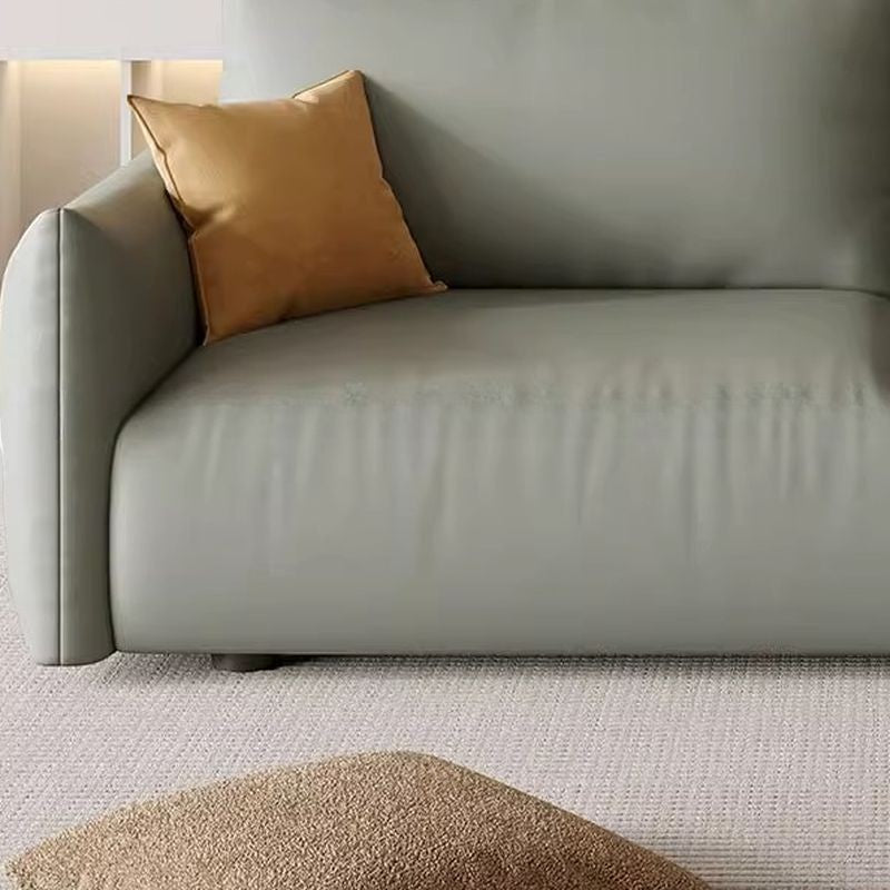Ambrosia Concepts Kreta 3-seater sofa in sage green faux leather with plush cushioning and a single gold accent pillow.