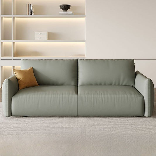 Ambrosia Concepts Kreta 3-seater sofa in sage green faux leather with clean lines and plush cushioning, featuring a single ochre throw pillow.