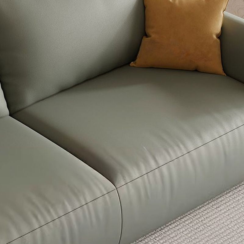 Ambrosia Concepts Kreta 3-seater sofa in sage green faux leather with plush cushioning and a mustard yellow accent pillow.